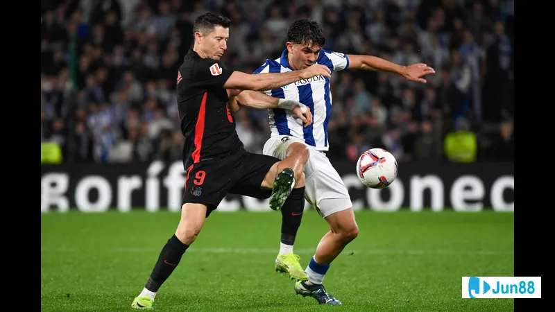 Cầu thủ Barca với sức mạnh vượt qua cầu thủ Real Sociedad trong tình huống tranh chấp bóng