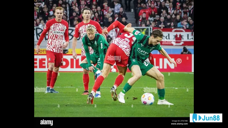 Cầu thủ Monchengladbach với bóng trước sự áp sát của cầu thủ Freiburg Cầu thủ Monchengladbach với bóng trước sự áp sát của cầu thủ Freiburg