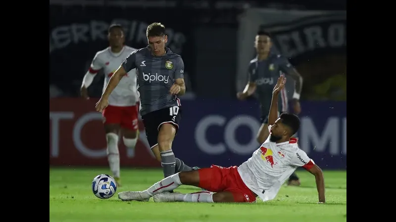 Cầu thủ từ đội Platense chạy nhanh với bóng trước sự áp đảo từ cầu thủ đội Deportivo Riestra Cầu thủ từ đội Platense chạy nhanh với bóng trước sự áp đảo từ cầu thủ đội Deportivo…